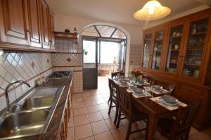 - une cuisine avec une table, des chaises et un évier dans l'établissement AMORE RENTALS - Villa Vanessa, à Positano