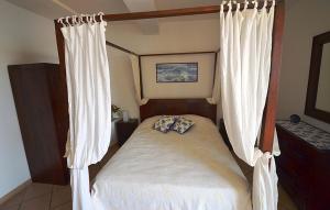 une chambre avec un lit à baldaquin avec rideaux dans l'établissement AMORE RENTALS - Villa Vanessa, à Positano 23 autres photos