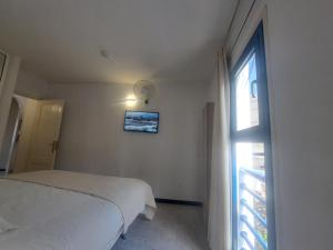 a white bedroom with a bed and a window at BEACHITO Puerto Naos in Puerto Naos
