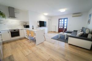 a kitchen and living room with a couch and a table at Apartment Moon in Pobegi