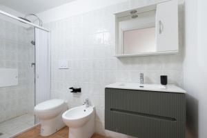 ein weißes Badezimmer mit Toilette und Waschbecken in der Unterkunft Biancolino Apartments in Nardò + 16 Fotos