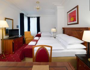 a hotel room with two beds and a television at Hotel Bologna in Prague