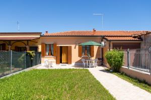 a small house with a green umbrella in a yard at Dimora Marina -apeliving- Pellestrina Ve in Pellestrina