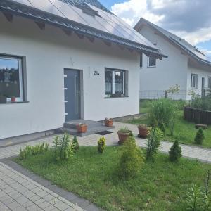 a white house with a blue door and some plants at Wiejski Zakątek in Domasławice +27 photos