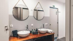 two sinks in a bathroom with two mirrors at Beachfront Caparica in Costa da Caparica +13 photos