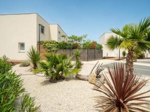 a yard with palm trees and a house at La Dune N 59 - Villa 3P6 in Sérignan