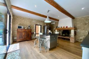 a kitchen with a stove and a counter top at La Maison de la Place - Charming house with swimming pool & exposed stone in Mudaison