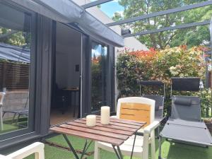 a screened in porch with a wooden table and chairs at Acero y Piedra Apartamentos con jardín privado in Cerceda
