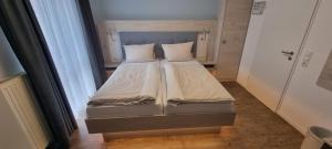 Una cama con dos almohadas encima en una habitación. en Hotel Restaurant Bootshaus, en Achim