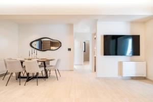 a dining room with a table and a flat screen tv at D&R Boutique Apartments Central in Rhodes Town