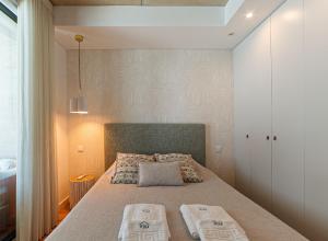 a bedroom with a bed with two pillows on it at Lina Beach Villa by Home Sweet Home Aveiro in Praia da Barra +46 photos