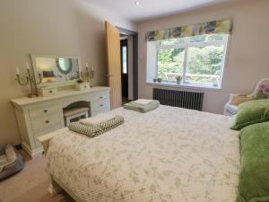een slaapkamer met een groot bed en een spiegel bij Nithbank Cottage in Thornhill