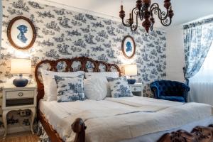 a bedroom with a bed with blue floral wallpaper at Hazai Provence in Kapolcs