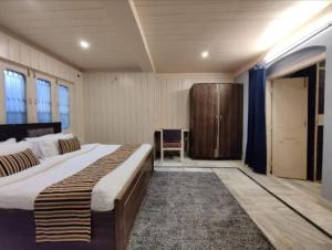 a bedroom with a large bed and a wooden cabinet at Mountain Glory Homestay in Mussoorie