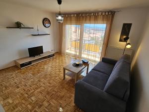 a living room with a couch and a tv at Apartmani Patača in Vodice