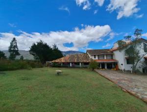 Una casa con un gran patio al frente. en Finca el belvedere, en Villa de Leyva