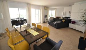 a living room with a table and yellow chairs at Nautilus Apartment in Armação de Pêra