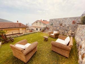 a yard with chairs and a table and a stone wall at Casa Vacanze Spigolatrice in Sapri