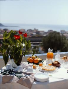 a table with food and a vase with a flower at Casa Vacanze Spigolatrice in Sapri
