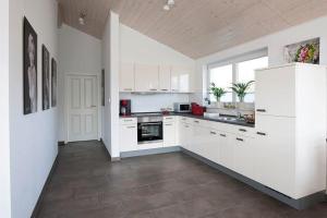 a white kitchen with white cabinets and a sink at Vechteblick - Nordhorn in Nordhorn