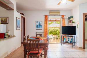 a dining room with a table and a television at Casa Nespolo in Tortolì
