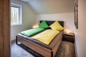 a bedroom with a bed with green and yellow pillows at VechteSchober in Nordhorn