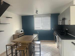 a kitchen with a table and some chairs in it at Sweet Harmony - Appart spacieux in Aulnay-sous-Bois