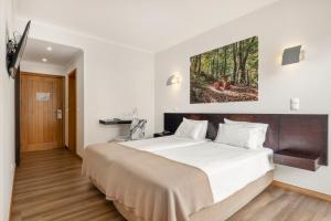 a bedroom with a large bed in a room at White Waters Hotel in Machico