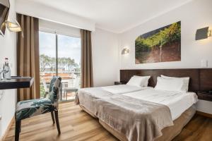 a hotel room with a bed and a window at White Waters Hotel in Machico