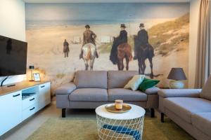 un soggiorno con un dipinto di uomini a cavallo di STRANDHAUS GRÖMITZ 2 a Grömitz