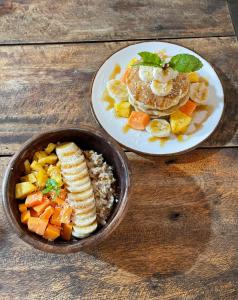 een bord pannenkoeken en een kom met fruit en groenten bij Agra Arugambay in Arugam Bay