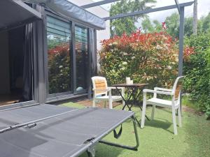 a patio with two chairs and a table and a table and chairs at Acero y Piedra Apartamentos con jardín privado in Cerceda