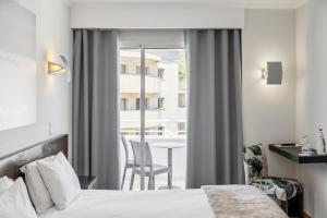 a hotel room with a bed and a balcony at White Waters Hotel in Machico