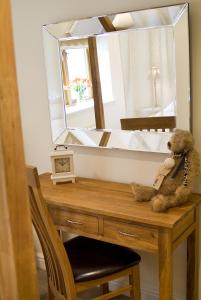 um urso de peluche sentado numa mesa em frente a um espelho em Longlands Inn & Cottages em Carnforth