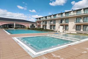 a large swimming pool in front of a building at Pamukkale Kaya Termal Otel in Pamukkale