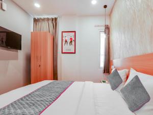 a bedroom with a large white bed with a tv at Super Townhouse CASA GRAND in Hyderabad