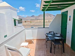 una mesa y sillas en un balcón con vistas al desierto en Casa Eric, en Playa Blanca 23 fotos más