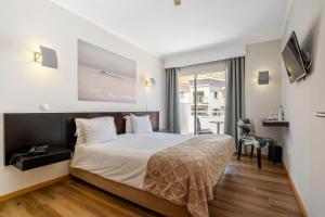 a hotel room with a bed and a balcony at White Waters Hotel in Machico