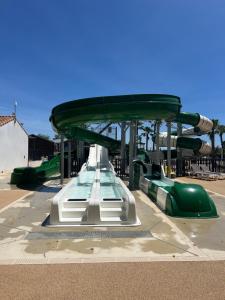 勒格罗-迪鲁瓦Mobil-home Camping -La Marine - 4 Étoiles - Grau du Roi - B038的公园里滑梯上的过山车