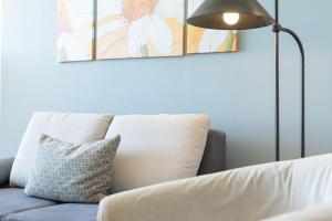 a white couch with a blue pillow and a lamp at Marina Wendtorf Schwalbennest in Wendtorf