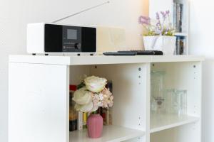 a white book shelf with a computer and flowers on it at Marina Wendtorf Schwalbennest in Wendtorf