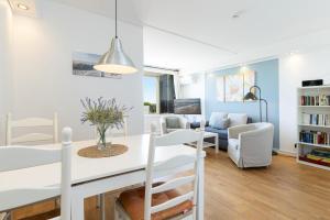 a dining room and living room with a table and chairs at Marina Wendtorf Schwalbennest in Wendtorf +22 photos