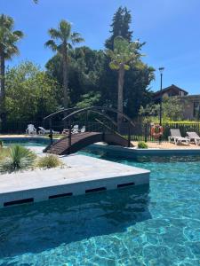 勒格罗-迪鲁瓦Mobil-home Camping -La Marine - 4 Étoiles - Grau du Roi - B038的游泳池和横跨游泳池的桥