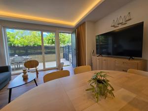 a living room with a table and a large television at Piso de lujo con gran terraza in Sanxenxo