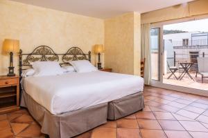 a bedroom with a large bed and a balcony at RVHotels Vila de Tossa in Tossa de Mar