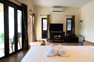 a room with two white towels on a bed at Saphli Villa in Chumphon