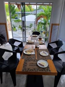 a dining room with a wooden table with plates of food at Futtaru Sands in Gaafaru +25 photos