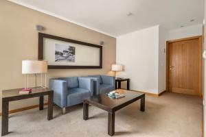 a living room with a blue couch and a table at White Waters Hotel in Machico