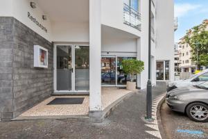 a building with a car parked in front of it at White Waters Hotel in Machico