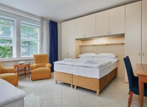 a bedroom with a large bed and a table and chairs at Hotel Bologna in Prague